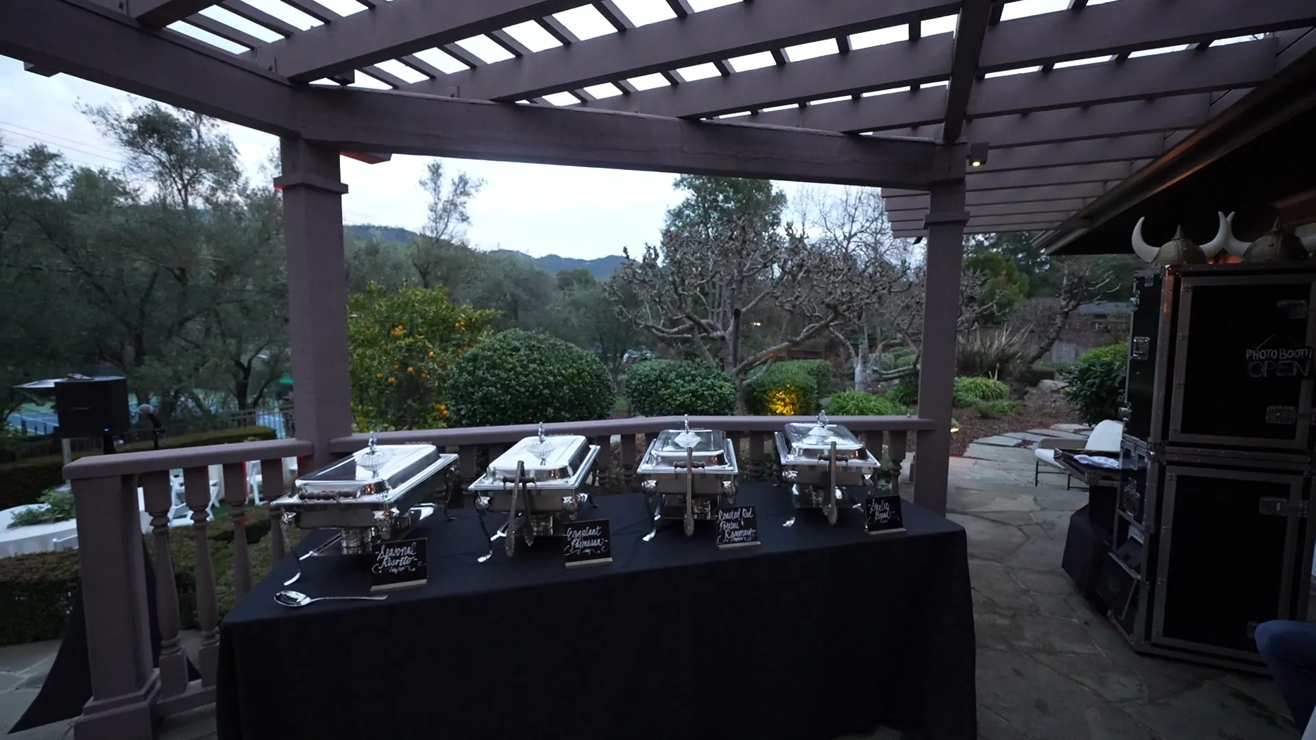 Chafing-dish buffet line set up under a pergola on a Pleasanton patio with the Tri-Valley hills behind it