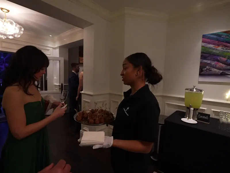 Uniformed attendant serving a guest from a passed tray at a San Ramon celebration