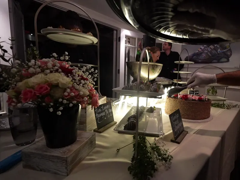 Dessert station with silver serving stands, fresh florals and chalkboard menu signs at a Pleasanton event
