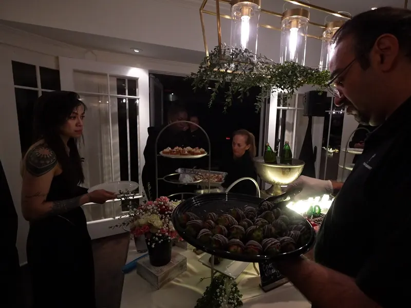Catering staff plating chocolate truffles onto a tray during a Tri-Valley party