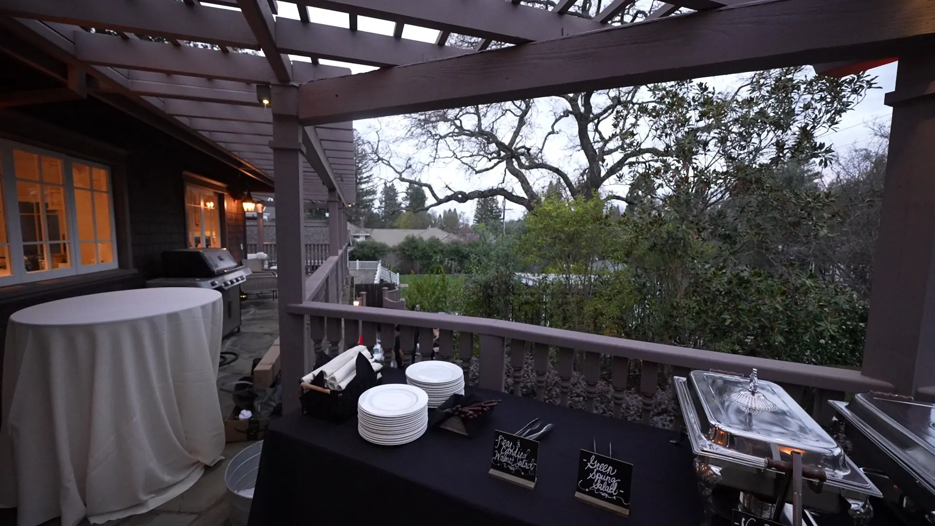 Buffet and bar set under a pergola surrounded by oaks at a Livermore wine country property