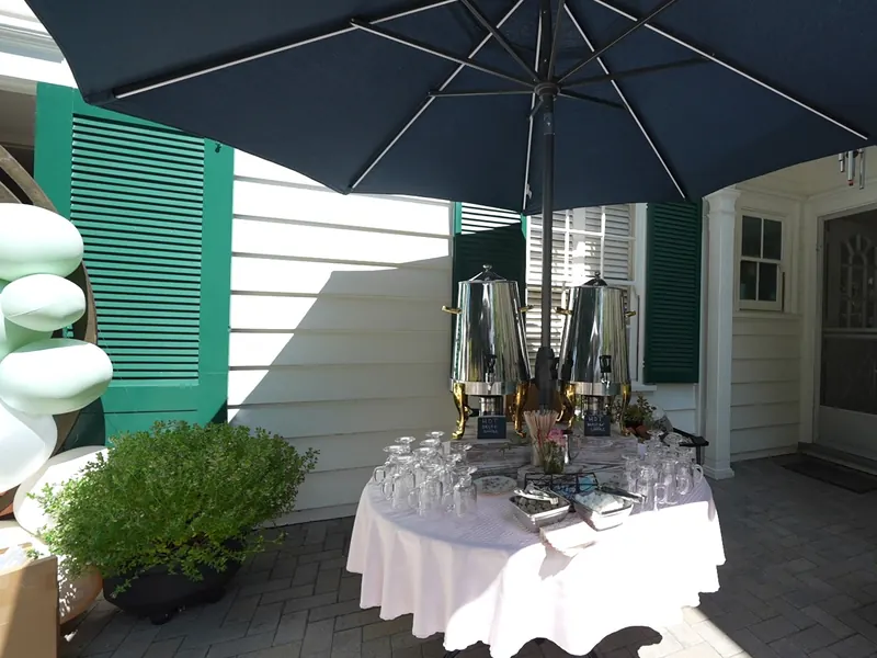 Coffee and beverage station with silver urns and glassware set on a San Ramon patio