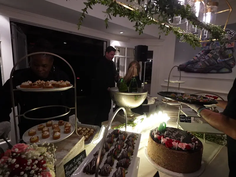 Tiered dessert display with chocolate-dipped strawberries and a birthday cake at a Dublin party