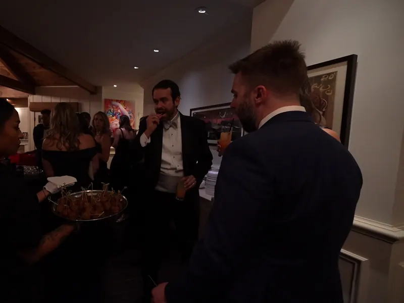 Guests in cocktail attire taking appetizers from a passed tray at a Castro Valley party