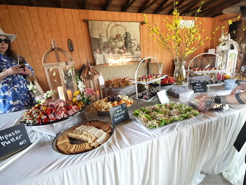 Grazing and antipasto table with chalkboard signs set along a wood wall at a Livermore barrel room