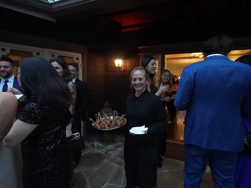 Server passing a tray of appetizers to guests during an evening gathering near Sunol