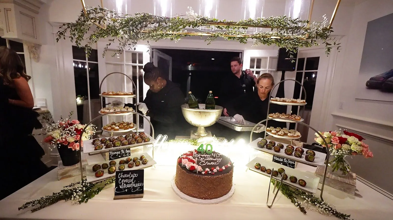 Dessert display of chocolate-dipped strawberries, celebration cake and petite sweets framed by fresh flower arrangements — dessert florals for Dublin catering parties