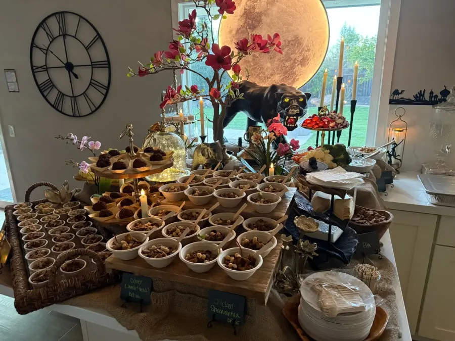 Mediterranean supper line of shawarma chicken, kebob and mezze dressed with greenery and blossom accents along the table — floral-styled Mediterranean service from Pleasanton catering